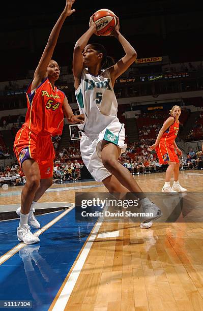 Stacey Lovelace-Tolbert of the Minnesota Lynx drives to the basket against Plenette Pierson of the Phoenix Mercury on July 9, 2004 at the Target...