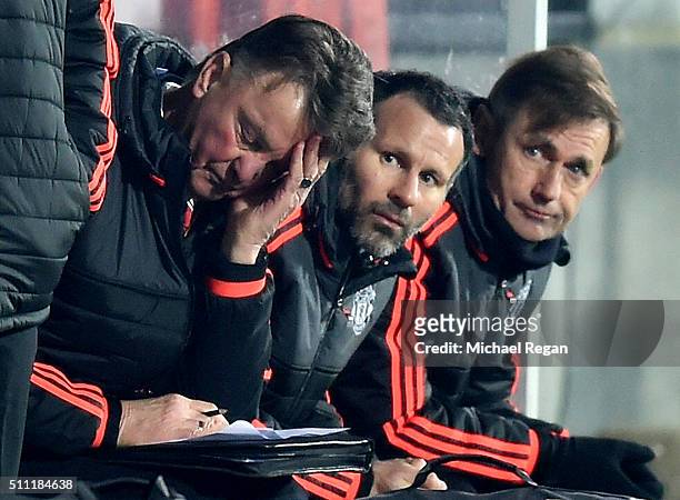 Louis van Gaal Manager of Manchester United scratches his head while Ryan Giggs assistant manager looks on during the UEFA Europa League round of 32...