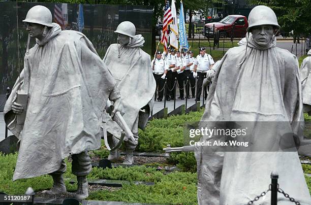 Korean War Veterans Color Guards march on the ground of the Korean War Veterans Memorial during a ceremony at the Korean War Veterans Memorial July...