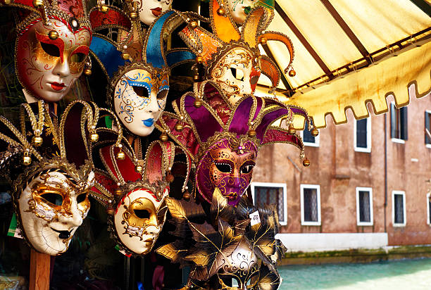carnival masks on display by canal in venice - venise photos et images de collection