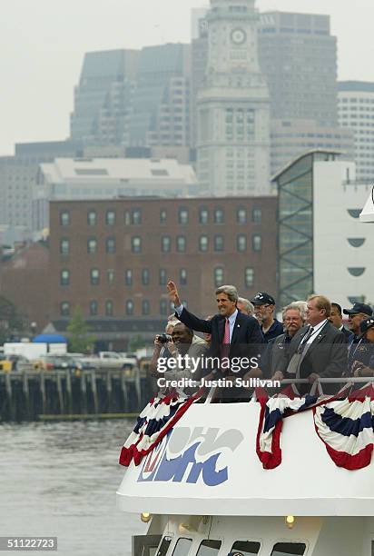 Democratic presidential candidate US Sen. John Kerry waves as he rides across the Boston Harbor enroute to a rally on a boat with former US Navy...