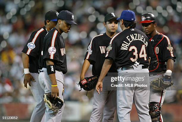 Andres Blanco, Robinson Cano, pitcher Arnaldo Munoz, manager Fernando Valenzuela and catcher Robinzon Diaz of the World Team huddle on the mound...