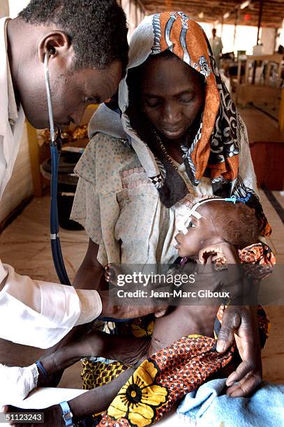 Severely malnourished child is tended to by nurses in the Medecins-sans-frontieres clinic December 4, 2003 in Maradi, Niger. Chronic malnutrition is...