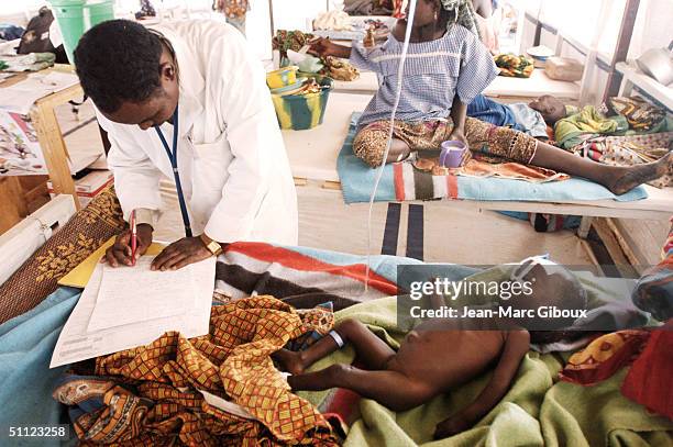 Severely malnourished child is tended to by Doctor Laouli Maman in the Medecins-sans-frontieres clinic December 4, 2003 in Maradi, Niger. Chronic...