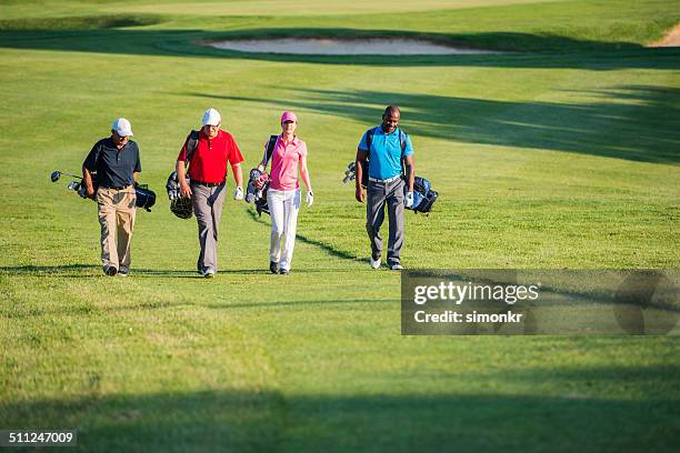 golfers walking on the golf course - four people stock pictures, royalty-free photos & images