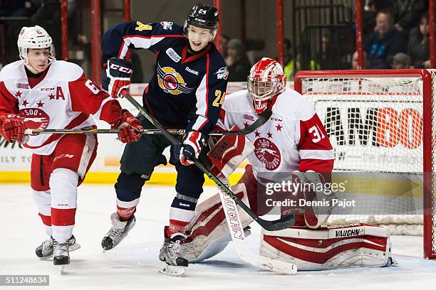 Forward Mads Eller of the Windsor Spitfires battles in front of the net against goaltender Brandon Halverson and defenceman Colton White of the Sault...