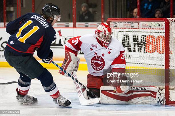 Goaltender Brandon Halverson of the Sault Ste. Marie Greyhounds battles for a rebound against forward Connor Chatham of the Windsor Spitfires on...