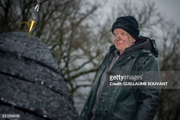 The british contemporary artist Andy Goldsworthy is pictured as he performs a slate cairn at the "Chateau de Chaumont-sur-Loire" castle on February...