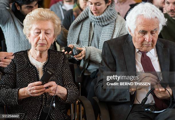 Holocaust survivors and witnesses William Glied and Irene Weiss fix their audio devices for the translation as they wait for the continuation of the...