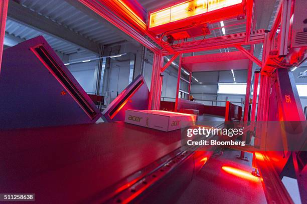Parcel is illuminated by red sensor light beams as it passes through a scanning machine, manufactured by Sick AG, at a mechanized postal delivery...