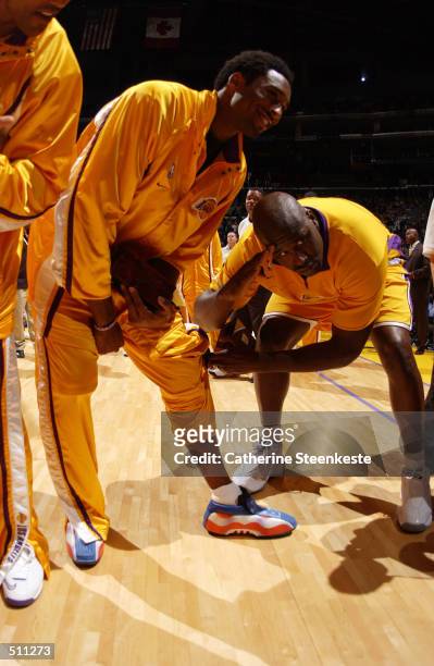 Shaquille O''Neal of the Los Angeles Lakers admires teammate Kobe Bryant's patriotic shoes before their game against the Portland Trail Blazers at...