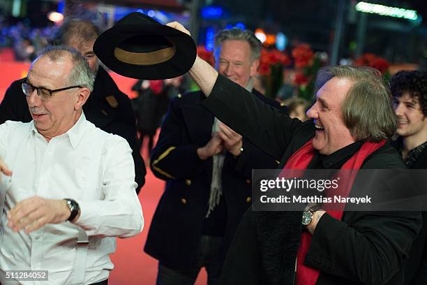 Gerard Depardieu, wearing Dieter Kosslick's scarf, also takes his hat and coat during the 'Saint Amour' premiere during the 66th Berlinale...