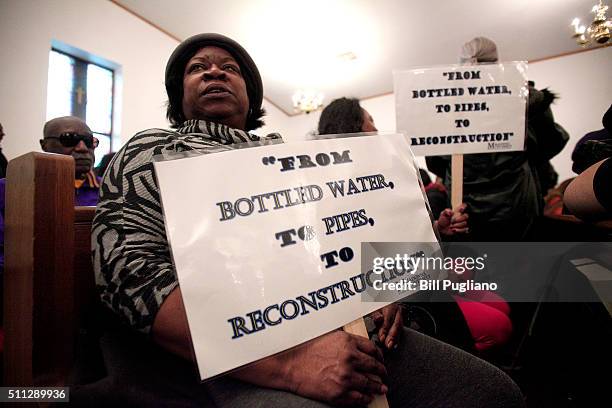 Woman holds a sign while attending a prayer service before participating in a national mile-long march to highlight the push for clean water in Flint...