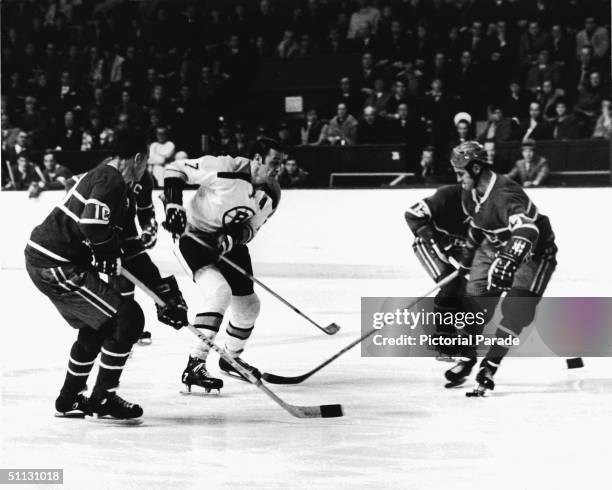 Canadian hockey player Phil Esposito of the Boston Bruins attempts to manouver through a group of players from the Montreal Canadiens team, Boston,...