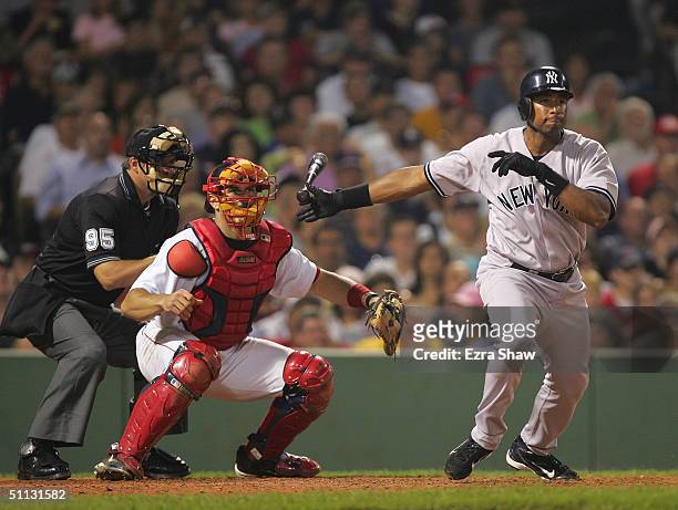 Bernie Williams of the New York Yankees releases his bat as he runs out of the batters during the game against the Boston Red Sox at Fenway Park on...