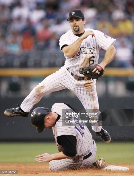 Second baseman Aaron Miles of the Colorado Rockies clears Chad Tracy of the Arizona Diamnondbacks to complete a double play against Juan Brito to end...