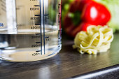 300ml Water In Measuring Cup On Kitchen Counter With Food