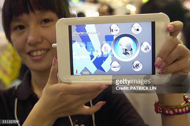 Staff member of Taiwan's MobiNote Technology Corp. Displays what she says is the world's first seven-inch portable video player, the DVX-POD 7010, at...