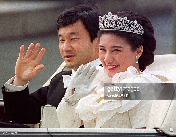 This file photo dated 09 June 1993 shows Japanese Crown Prince Naruhito and Crown Princess Masako waving to people during the parade after their...