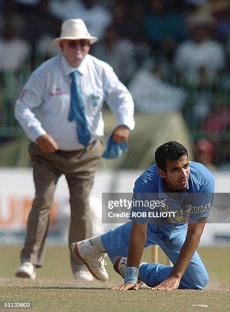 India cricketer Zaheer Khan is watched by umpire David Shepherd as he falls over in a run out attempt on unseen Sri Lanka cricket captain, Marvan...