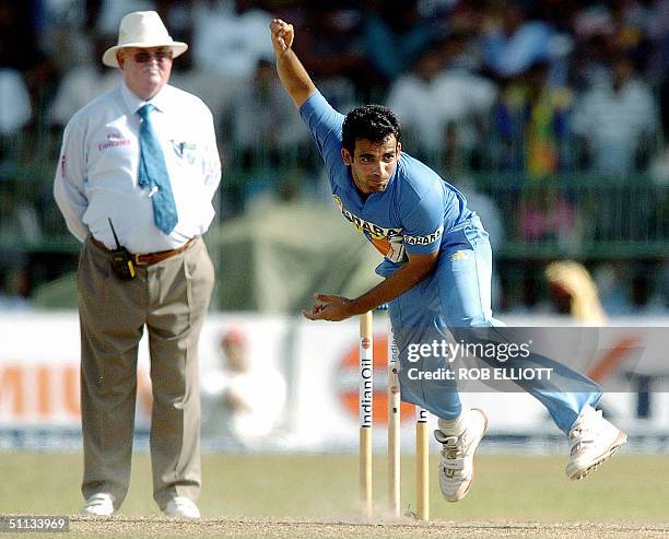 India bowler, Zaheer Khan gets airborne as he makes a delivery as umpire David Shepherd watches at the R. Premadasa International Cricket Ground in...