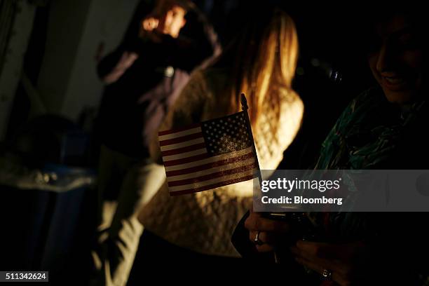 An attendee holds a U.S. Flag onboard the decommissioned U.S.S. Yorktown aircraft carrier before a campaign event for John Kasich, governor of Ohio...