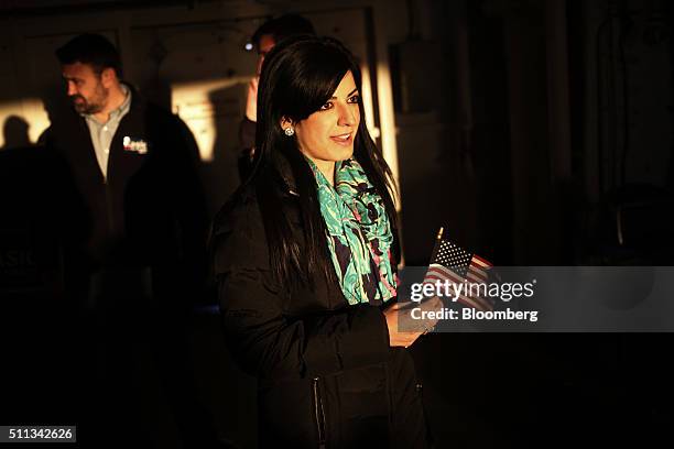 An attendee holds a U.S. Flag onboard the decommissioned U.S.S. Yorktown aircraft carrier before a campaign event for John Kasich, governor of Ohio...