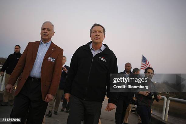 John Kasich, governor of Ohio and 2016 Republican presidential candidate, center, walks toward the decommissioned U.S.S. Yorktown aircraft carrier as...