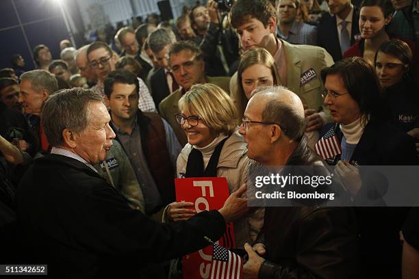 John Kasich, governor of Ohio and 2016 Republican presidential candidate, left, greets attendees during a campaign event at the Patriots Point Naval...