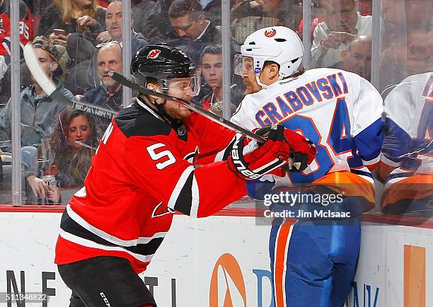 Adam Larsson of the New Jersey Devils checks Mikhail Grabovski of the New York Islanders during the third period at the Prudential Center on February...