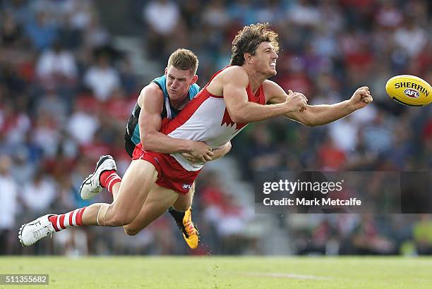 Kurt Tippett of the Swans handpasses the ball as he is tackled by Matthew White of the Power during the 2016 NAB Challenge AFL match between the...