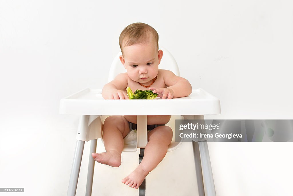 Baby feeding on broccoli