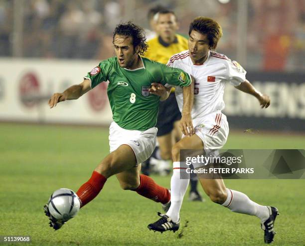 Iran's Ali Karimi tries to get the ball pass China's defender Zheng Zhi during the Asian Cup semifinal match 03 August 2004 in Beijing. China and...