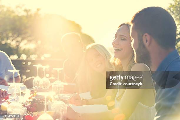 group of young people eating outdoors. - evening meal restaurant stock pictures, royalty-free photos & images