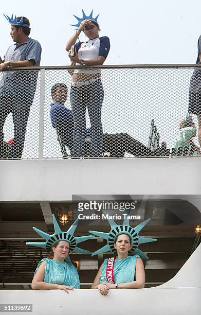Passengers dressed as Lady Liberty arrive on a boat outside the Statue of Liberty August 3, 2004 in New York City. The Statue's pedestal was opened...