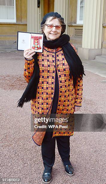 Sculptor Phyllida Barlow holds her Commander of the British Empire medal after it was presented to her by the Prince Charles, Prince of Wales during...