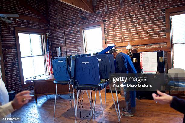 Meggett, SC An election official hands an "I Voted Today" sticker to a woman who has just voted in the South Carolina Republican Presidential...