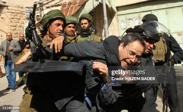 Israeli soldiers arrest an Israeli protester during clashes following a demonstration against Jewish settlements and the closing of al-Shuhada street...