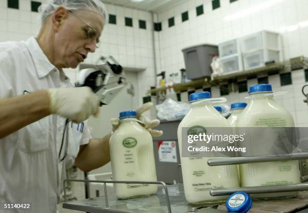 Processor Wayne Gaver places the expiration date on milk products while working on the bottling line of South Mountain Creamery, a farm that provides...