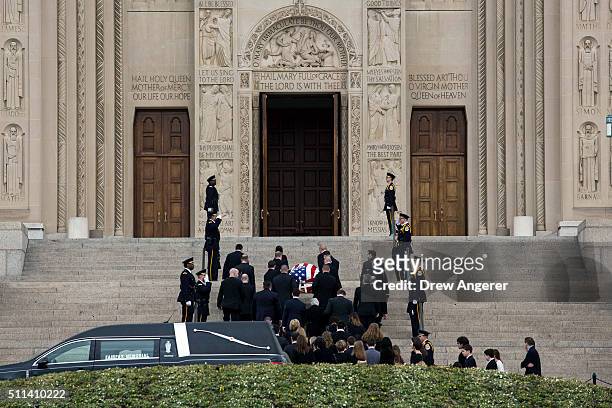 With family members following behind, pallbearers carry the casket of late Supreme Court Justice Antonin Scalia up the steps of the Basilica of the...