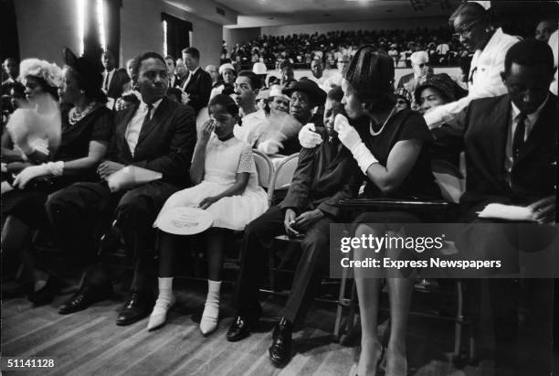 At the funeral for slain Civil Rights leader Medgar Evers, his wife, Myrlie Evers , comforts their son, Darryl Kenyatta Evers, while daughter Reena...