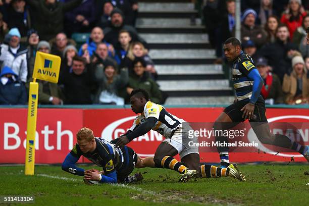 Tom Homer of Bath scores his sides opening try despite the challenge from Christian Wade of Wasps during the Aviva Premiership match between Bath and...