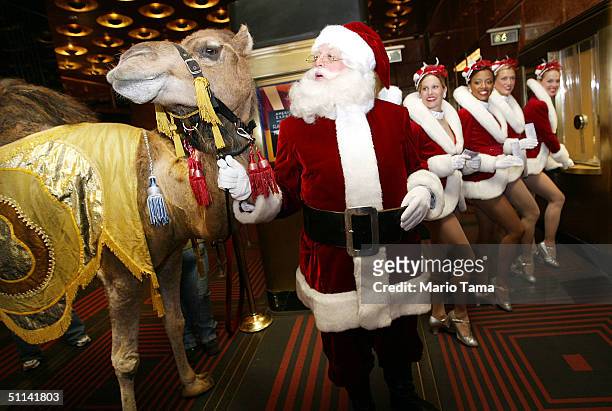 The Radio City Rockettes, Santa Claus and a camel pose in the ticket window to promote the Radio City Christmas Spectacular at Radio City Music Hall...