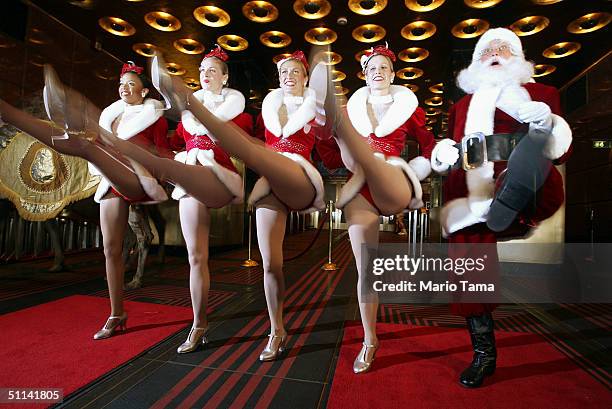 The Radio City Rockettes and Santa Claus dance in the ticket window to promote the Radio City Christmas Spectacular at Radio City Music Hall August...