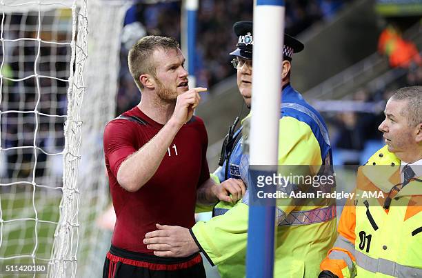 Chris Brunt of West Bromwich Albion is held back by a police officer as he tries to confront the fan who up threw a coin at him after the Emirates FA...