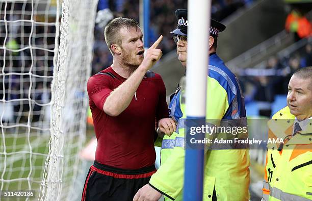 Chris Brunt of West Bromwich Albion is held back by a police officer as he tries to confront the fan who up threw a coin at him after the Emirates FA...