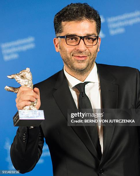 Bosnian director Danis Tanovic poses with his the Silver Bear Grand Jury Prize trophy for his film "Death in Sarajevo" during a photocall at the...
