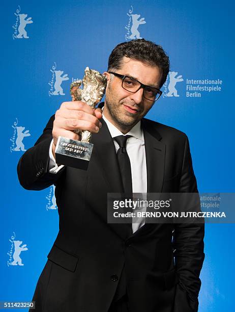 Bosnian director Danis Tanovic poses with his Sthe Silver Bear Grand Jury Prize trophy for his film "Death in Sarajevo" during a photocall at the...
