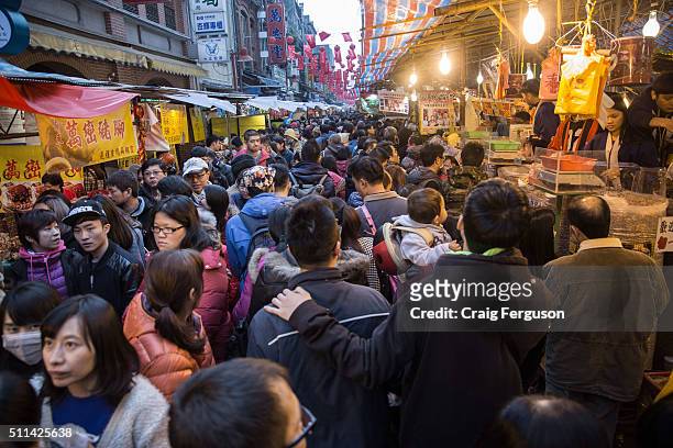 Masses of people gather to buy snacks on the final day before the Chinese lunar new year holiday officially starts. Dihua St in Taipei has long been...