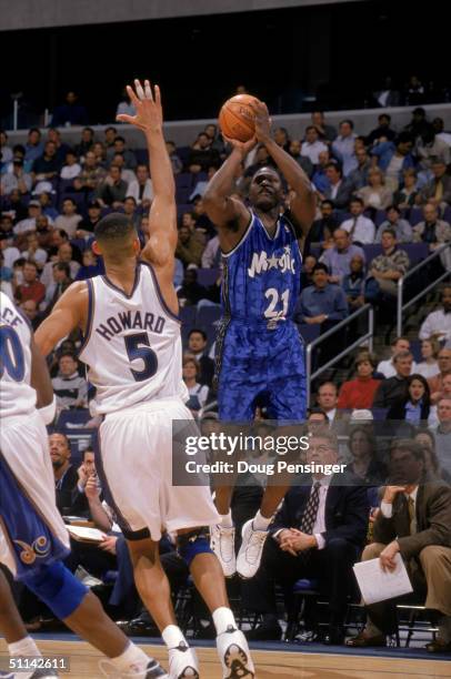 Dominique Wilkins of the Orlando Magic shoots a jump shot over Juwan Howard of the Washington Wizards during the game at MCI Center on March 31, 1999...